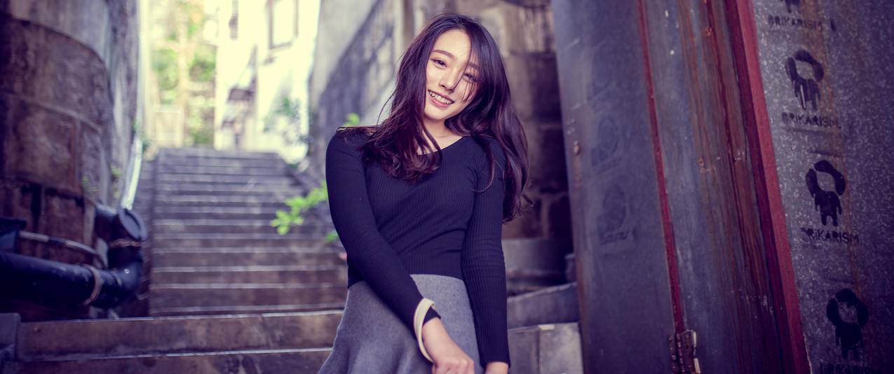 黑色毛衣微笑的美女带鱼屏壁纸