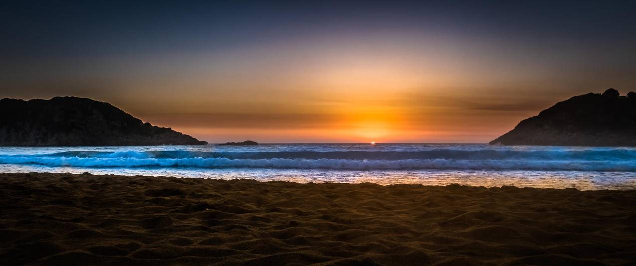 夕阳西海天空夜晚海滩希腊风景带鱼屏壁纸